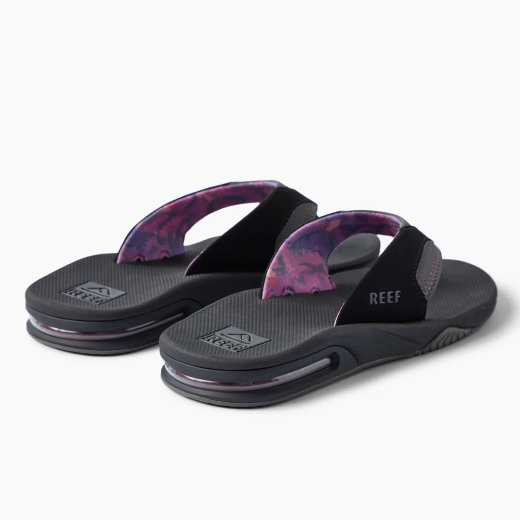 REEF Fanning black flip flops facing left with patterned straps and cushioned footbeds