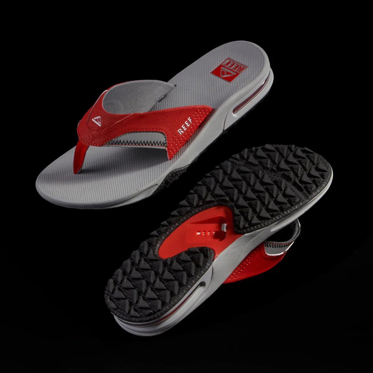 Pair of Fanning Pregame sandals for men with red and grey straps, showing top and textured sole, beach inspired comfort.