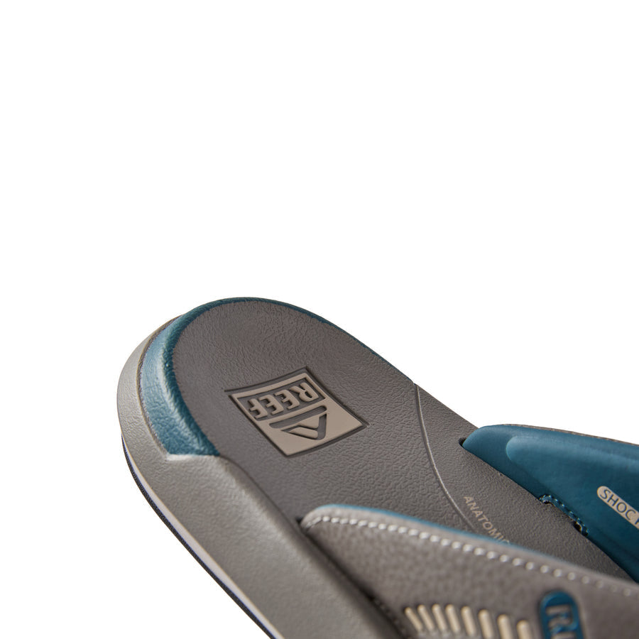 Close-up of the Cruiser sandal heel facing left, showing grey and blue water-friendly, arch support styles with REEF comfort technology.