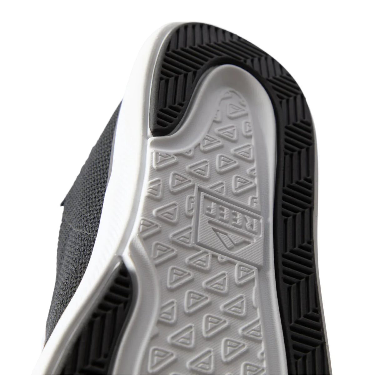Close-up of the black Neptune HT shoe sole facing upward, showing durable, water-friendly tread with REEF comfort technology.