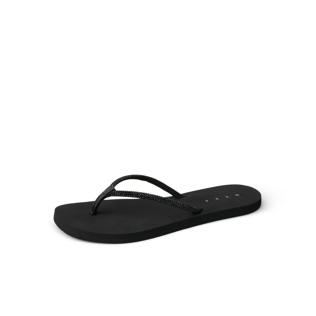 Bliss Bling Fling black flip flop facing right, close-up of front straps, beach-inspired comfort with arch support.