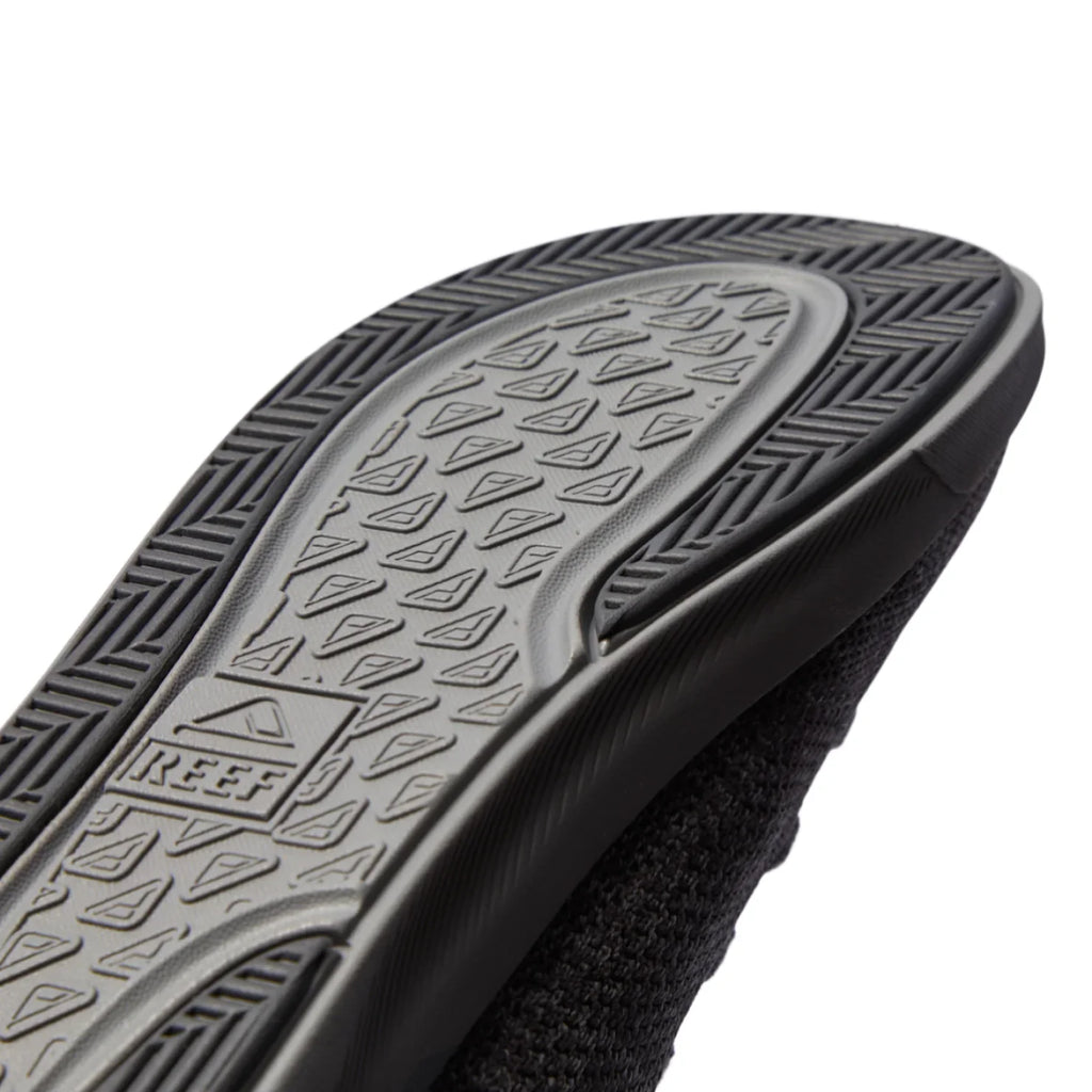 Close-up of the Neptune HT sole facing up showing durable textured tread and REEF logo with extra cushioning and arch support features.