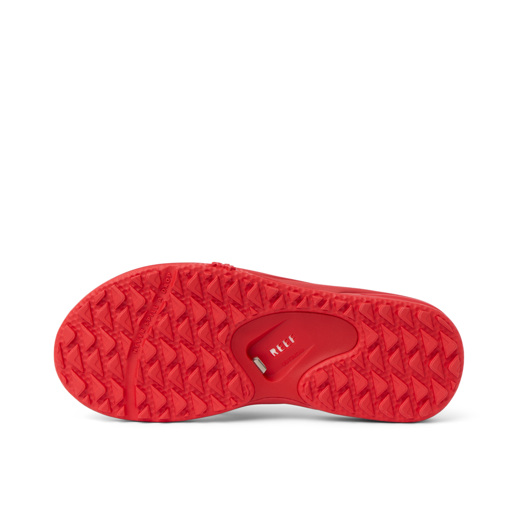 Fanning Pregame red shoe outsole facing up, showing durable water-friendly tread with anatomical arch support design.