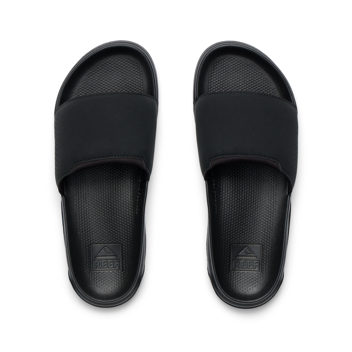 Tailslide men's black slides facing up, close-up of footbeds with textured cushioning and arch support for water-friendly comfort.