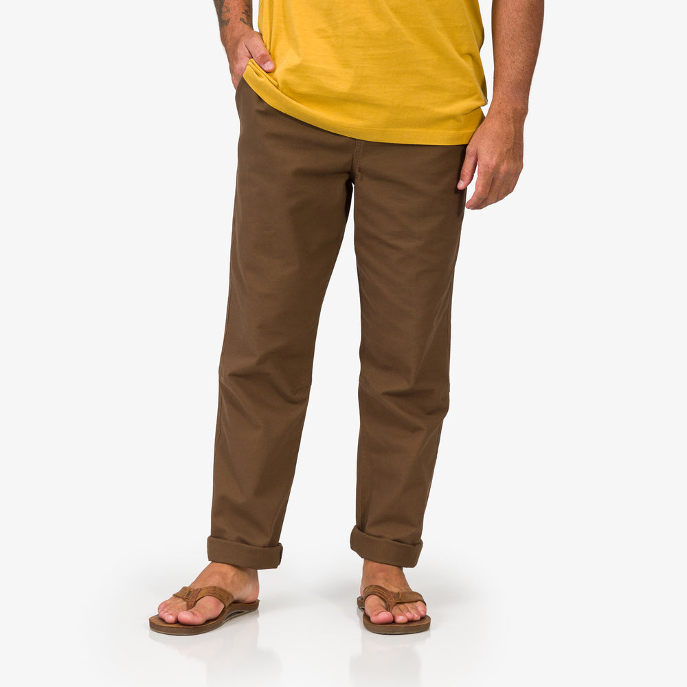 Front view of Matthew Twill Pant in brown worn with REEF sandals, showing relaxed fit and cuffed hems for beach comfort.