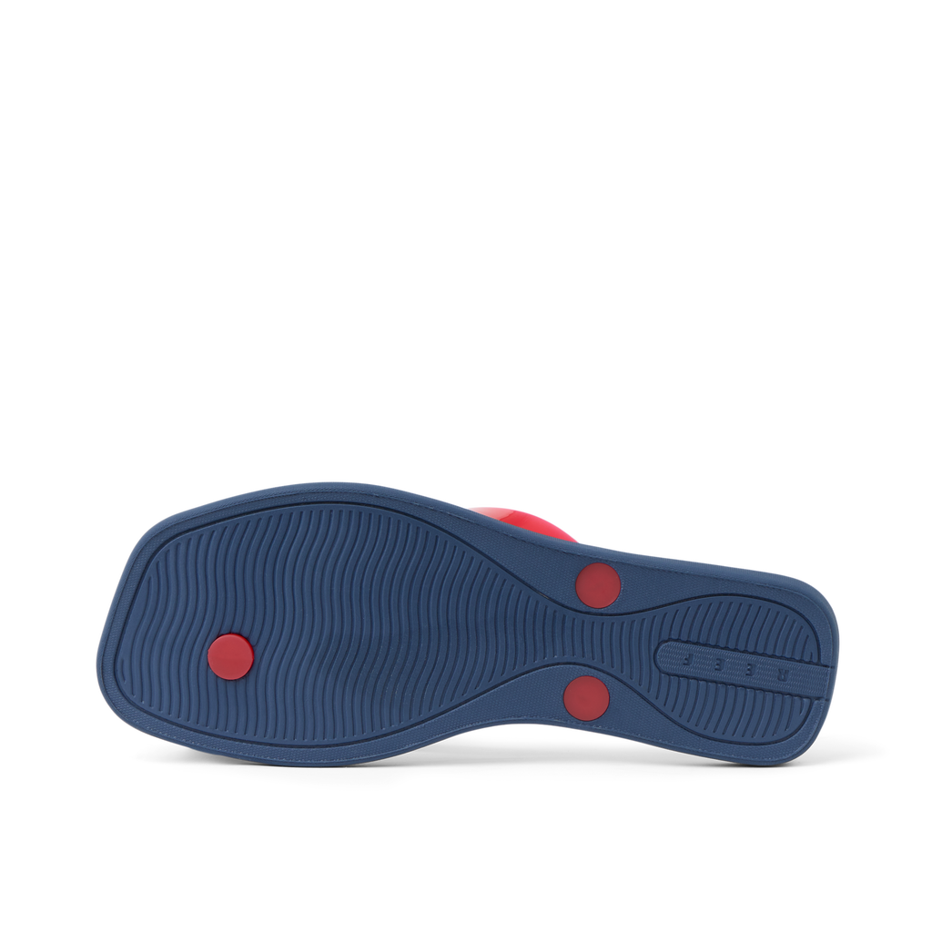 Solaye women's footwear showing outsole in navy blue with red circular accents, surf-inspired comfort design