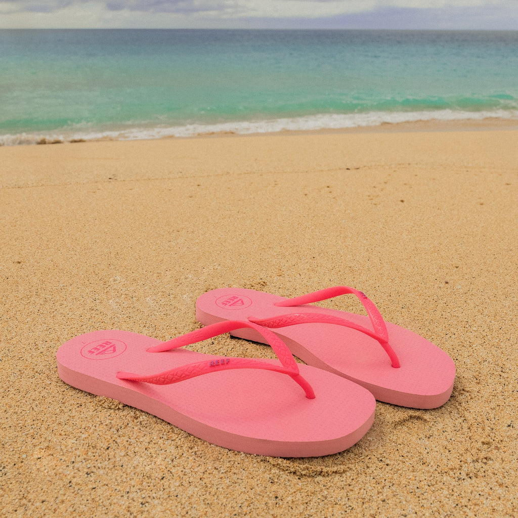 Seaside Square Toe pink sandals facing right on sandy beach with ocean background, designed for comfort and durability.