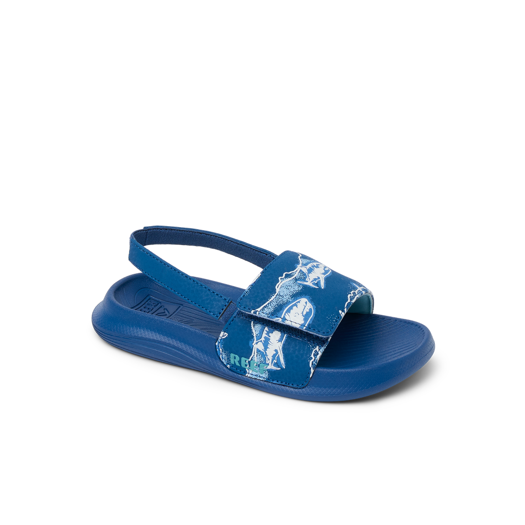 Little Salty Slide boys’ sandal facing left, close-up of front strap with surf-inspired print and cushioned sole.