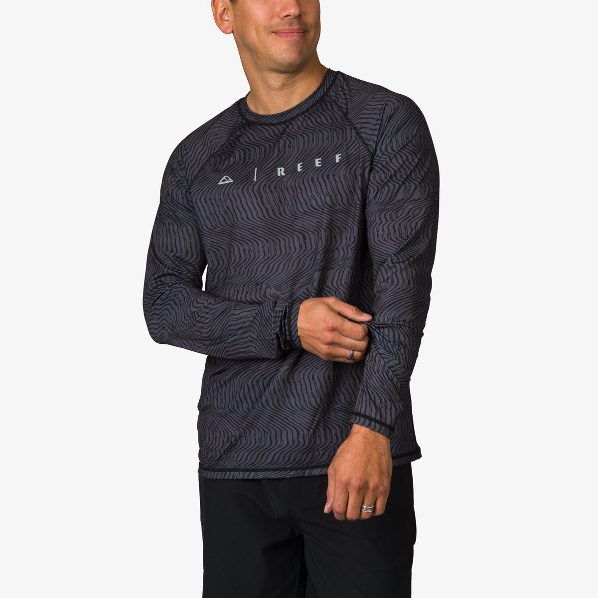 Man wearing a black patterned Dune Performance Shirt facing slightly left, showing front and left sleeve details.