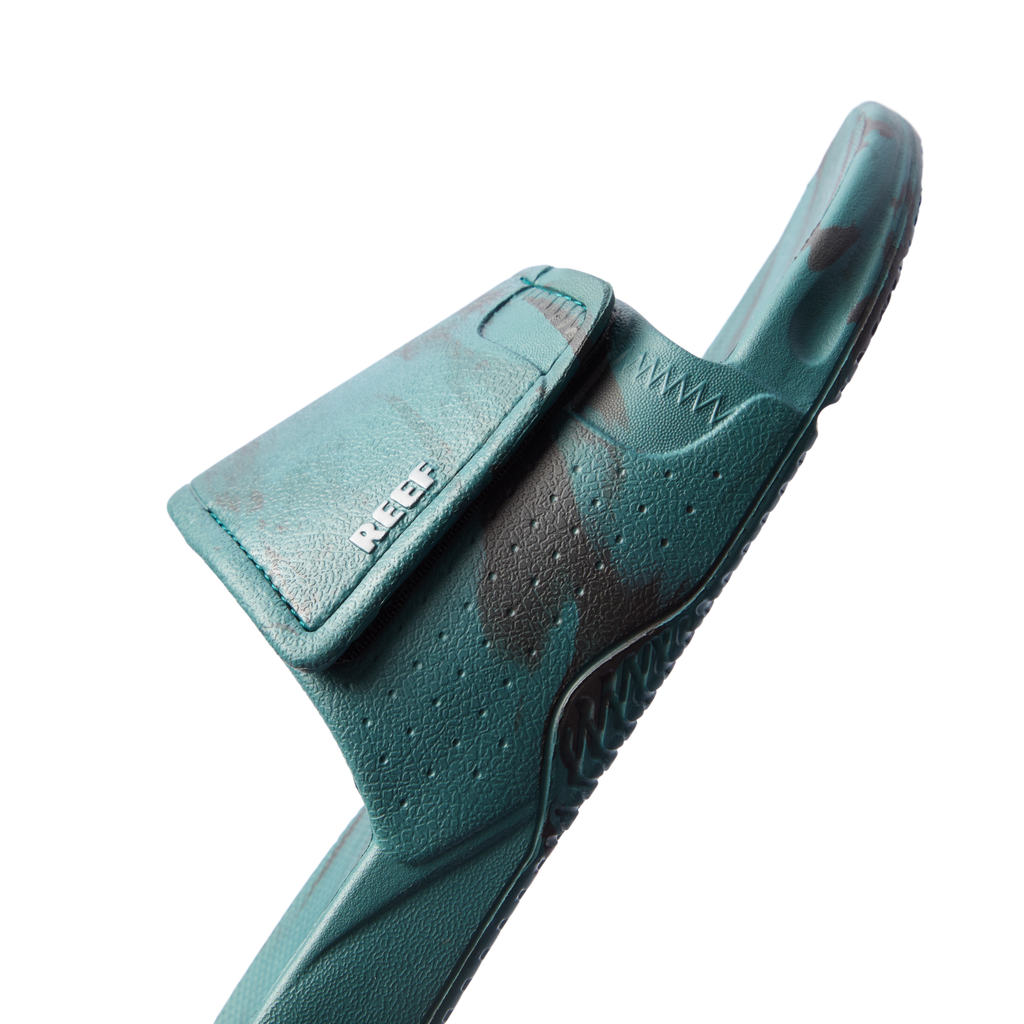 Fanning Slide H2O in deep teal marble facing right, close-up on front strap with breathable perforations and arch support.