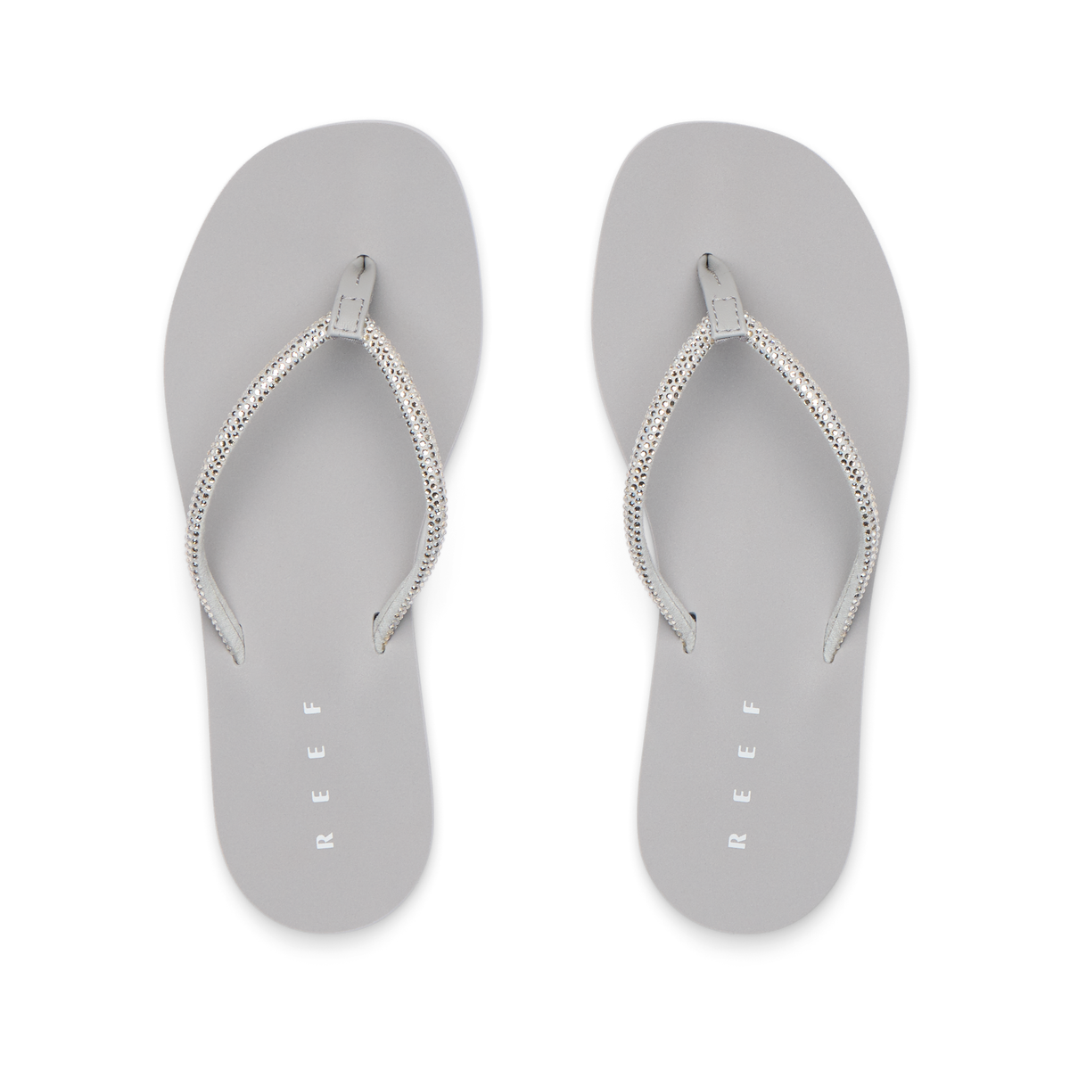Bliss Bling Fling silver women's flip flops facing up, featuring surf-inspired comfort and soft cushioning for the beach.