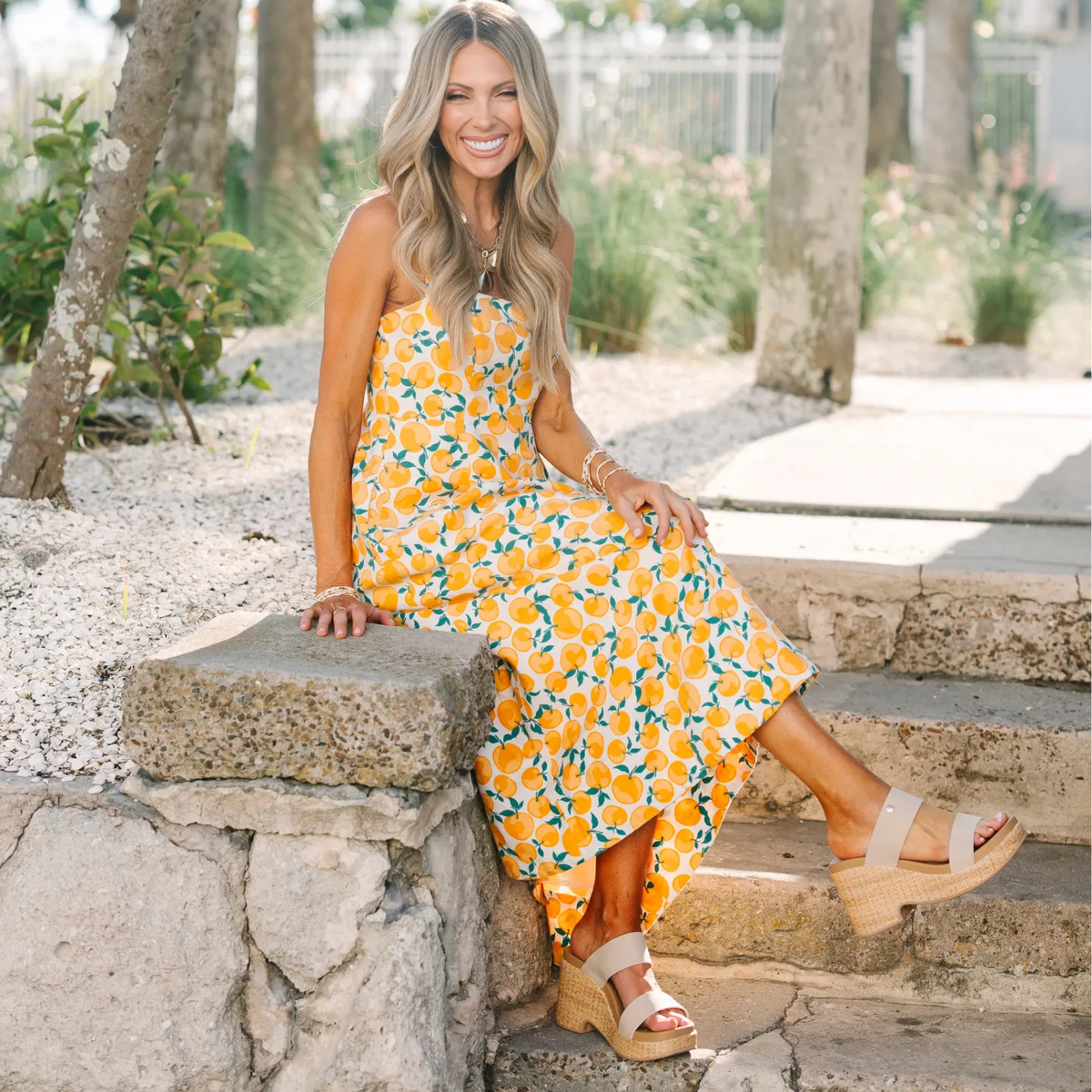 Sunset Ibiza x Jenny sandals facing right on model seated outdoors, featuring woven platform and beach-inspired comfort