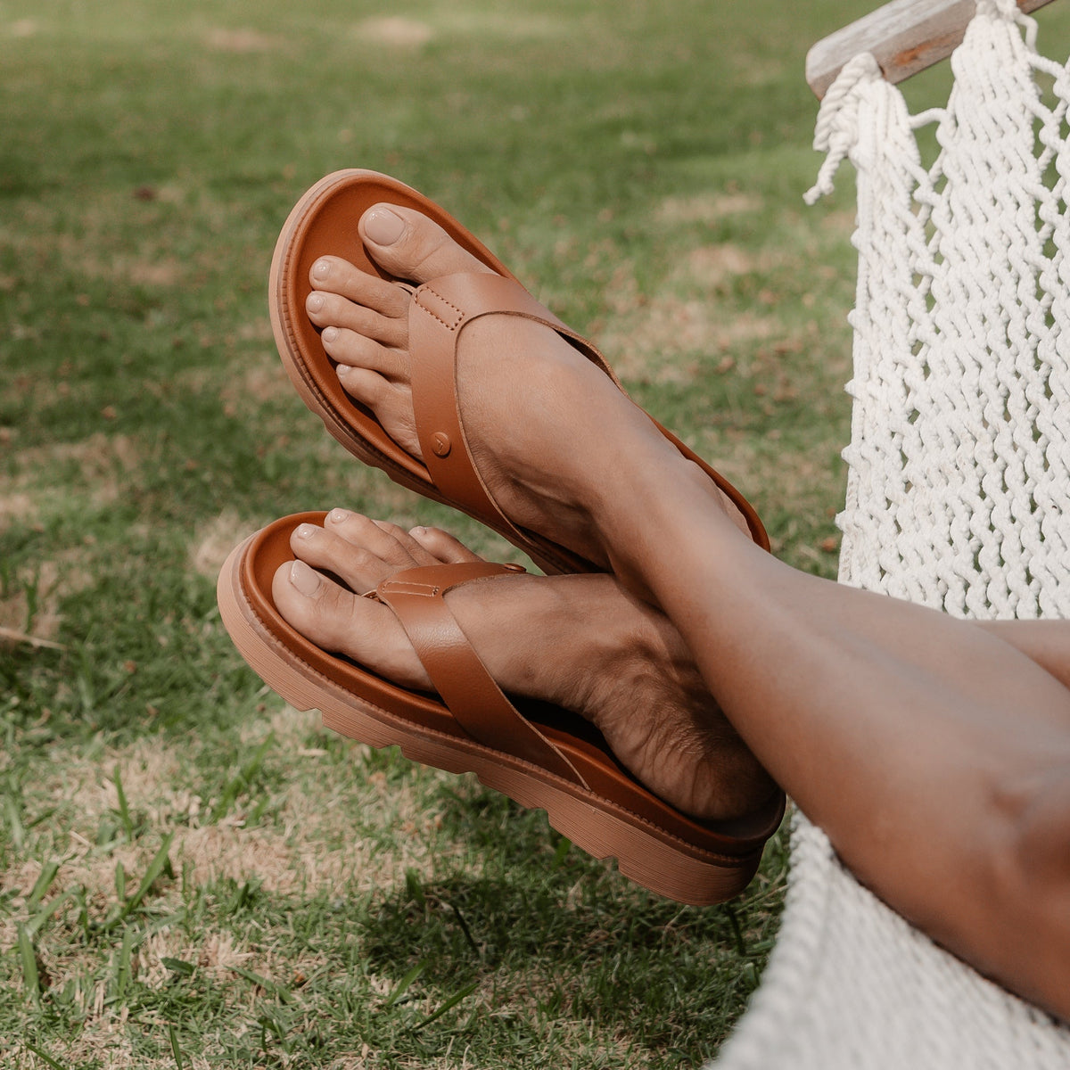 Vista Luxe Vivianahh tan sandals with anatomical arch support, facing left on woman's feet resting on hammock outdoors