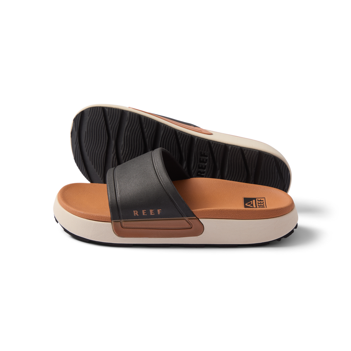 Sydnee Cutback Low women's black and tan slide sandals side view showing soft-rebound cushioned footbed and textured outsole