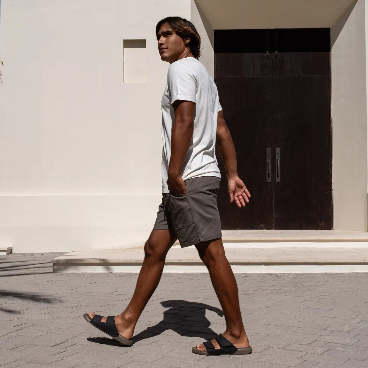 Man walking right wearing Oasis Adapt sandals facing right, showing side view with comfort and arch support design
