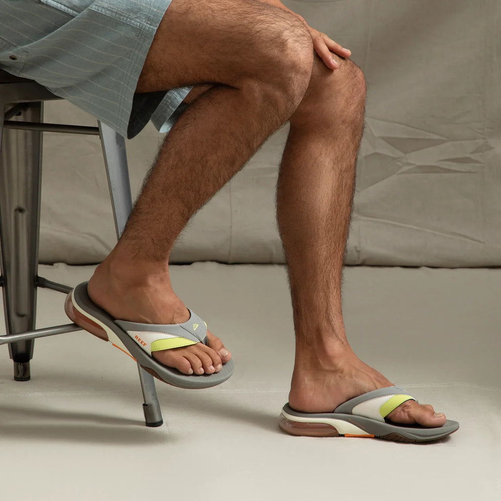 Fanning + men's grey flip flops facing right, showing top and side view with arch support and cushioned sole, beach-inspired design.
