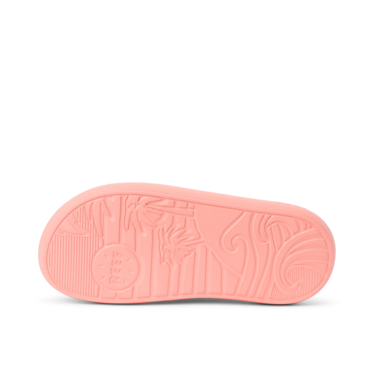 Kids Rio Slide coral outsole facing up, showing textured grip with surf-inspired patterns and Reef branding.