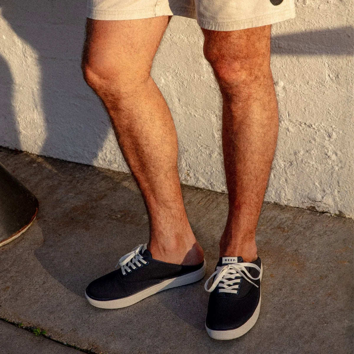 Men's feet wearing navy Neptune Lido sneakers facing forward, showcasing lightweight, comfortable beach-inspired footwear.
