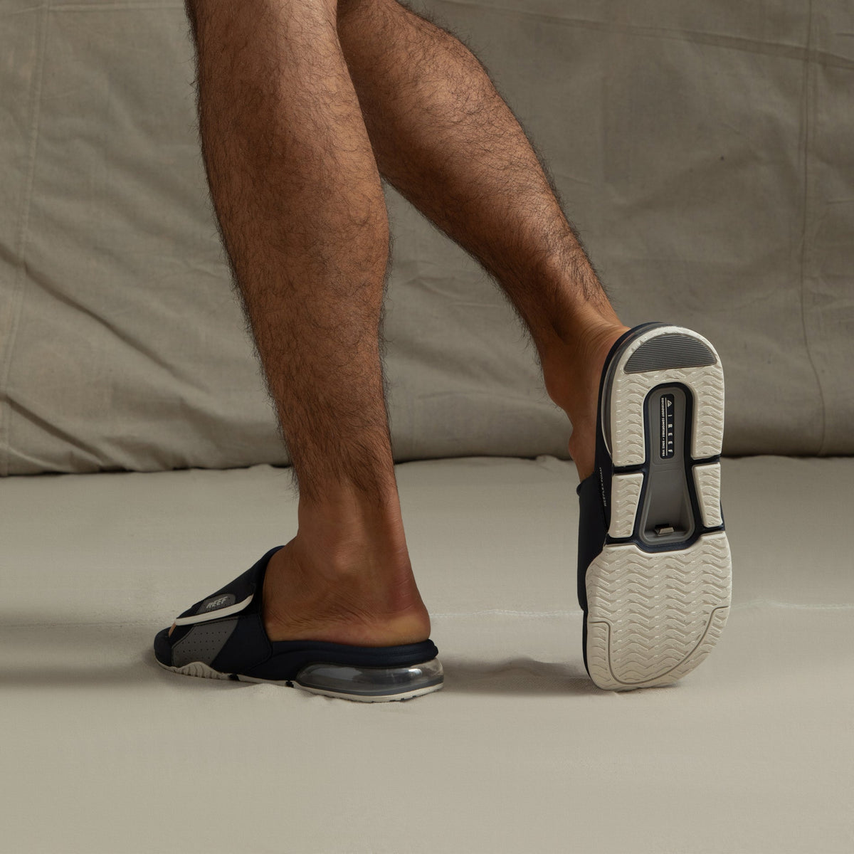 Fanning + Slide sandals facing back and left, featuring navy and grey water-friendly straps with cushioned REEFlex EVA sole and airbag heel cushioning